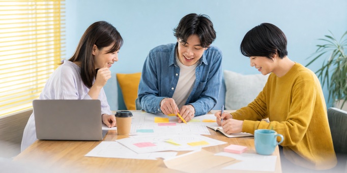 明るい会議室でアイデアを出し合う日本人チーム