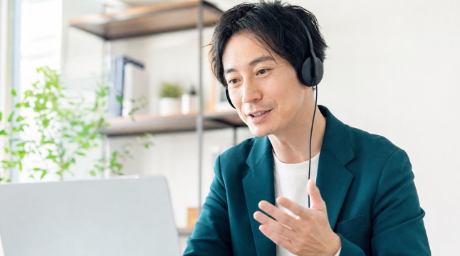 ヘッドセットを着けてオンライン相談に応じる日本人コンサルタント